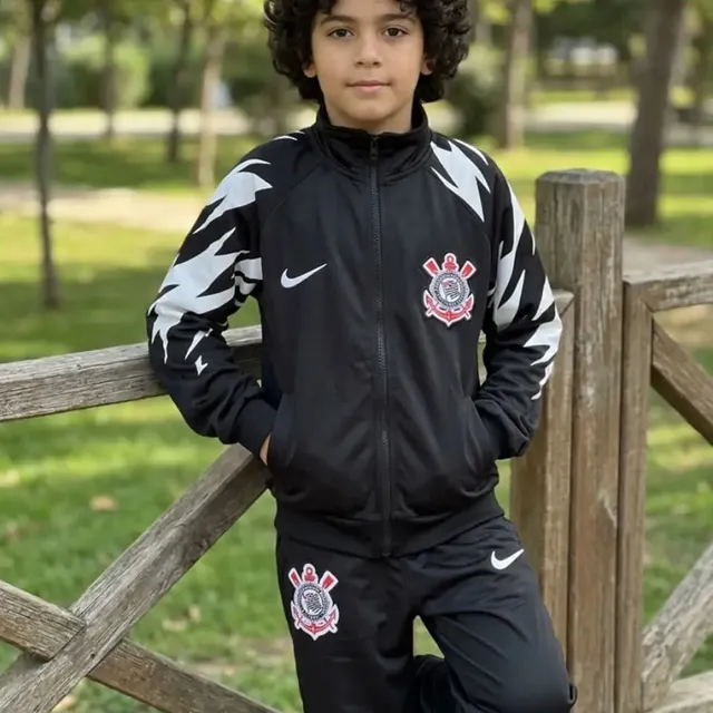 Criança com agasalho preto do Corinthians